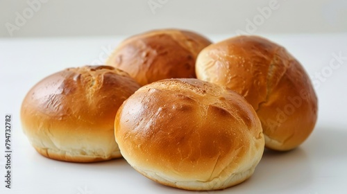 Four bread rolls on white surface