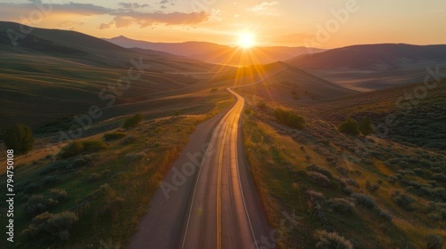 The sun sets over a tranquil mountain pass its last rays casting a warm glow on the empty road ahead. . AI generation. photo