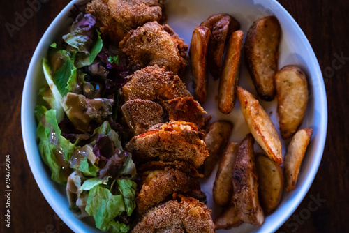 Delicious and crispy prawns with potato wedges and salad served in a plate. Authentic deep fried tiger prawn recipe from Goa, India.
 photo