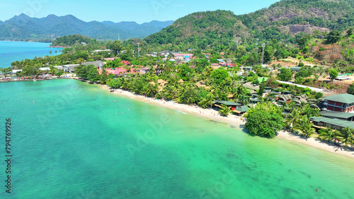 A drone's view reveals a stunning tropical coastline - beaches, resorts, lush mountains, and endless blue skies combine to create a picture-perfect paradise. Mu Ko Chang National Park, Thailand. 