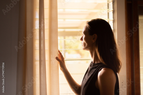 woman looking through window thinking pondering 