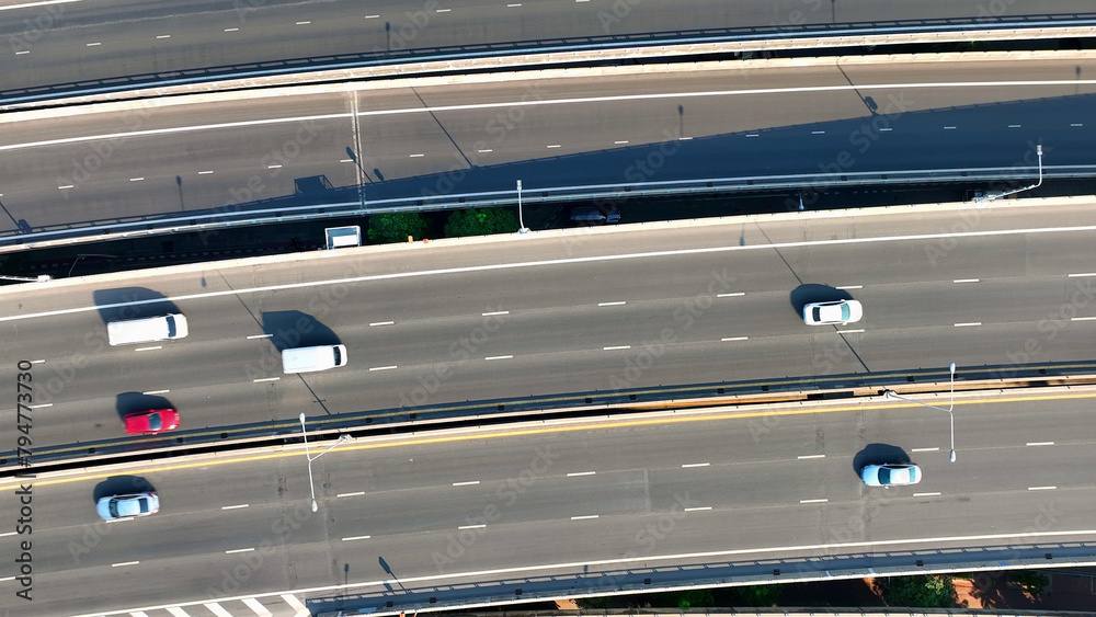 Fototapeta premium Aerial view, Flying above the expansive highway, the drone provides a bird's-eye view of the intricate network of roads, symbolizing progress in transportation. Traffic concept. Bangkok, Thailand. 