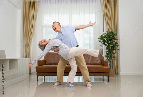cheerful asian senior couple having fun dancing in the living room,family lifestyle,relationship,romantic,togetherness © Verin