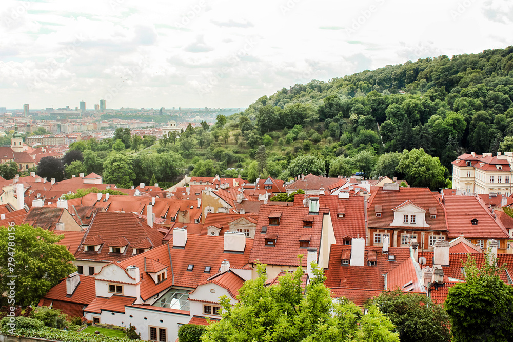 A landscape of picturesque houses with roofs made of brown tiles. Beautiful picturesque view from the height of the city of Prague. Travel and tourism concept