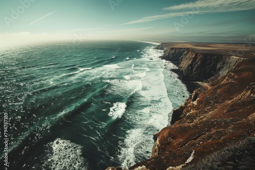 A wide-angle shot capturing the vast ocean meeting rugged cliffs from a high vantage point