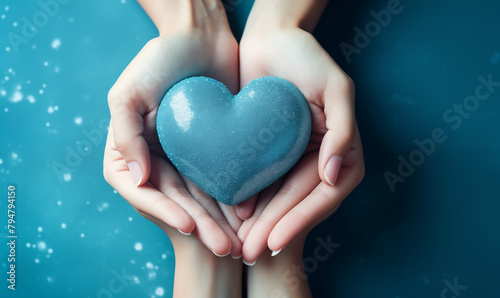 Two hands holding a heart on a blue background