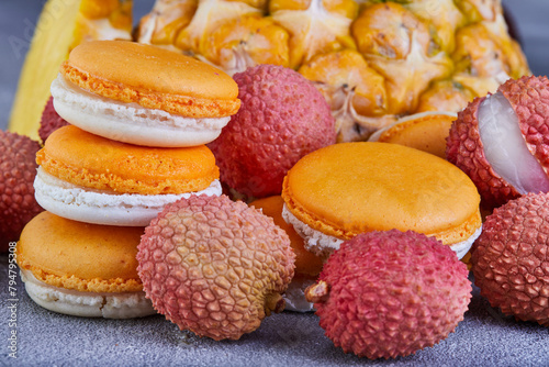 Assorted fruits like pineapple, lychee, and macarons displayed on a table photo