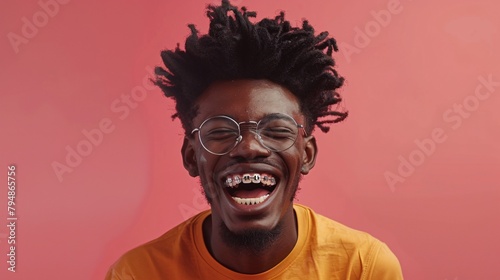 An advertisement featuring a comical young man with curly hair, glasses, and metal braces showcasing his bright smile against a pink backdrop.