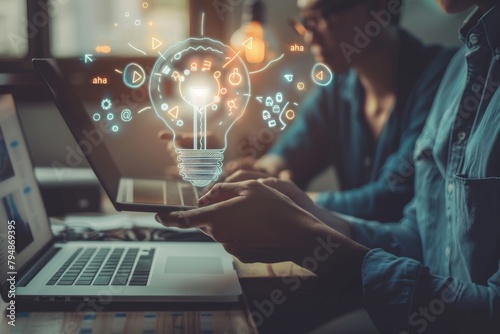 A man's hands emerge from a laptop, merging technology with a glowing light bulb, portraying digital ideas and solutions photo