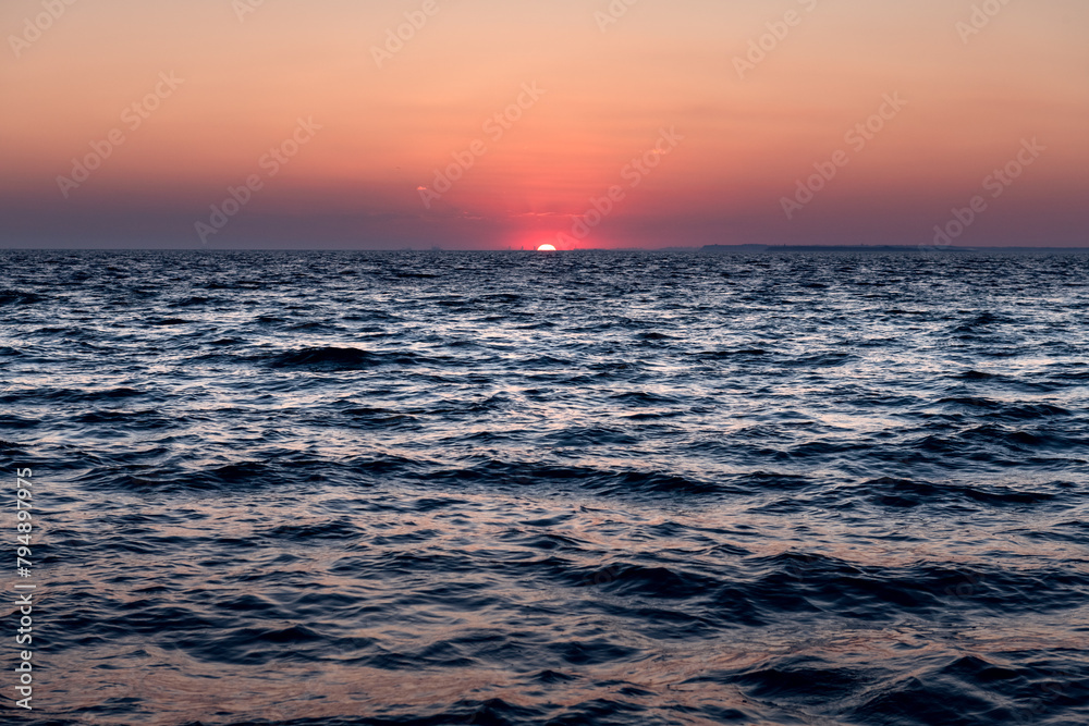 Sunset in the ocean with soft waves