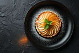 Tart with pear on a dark plate background