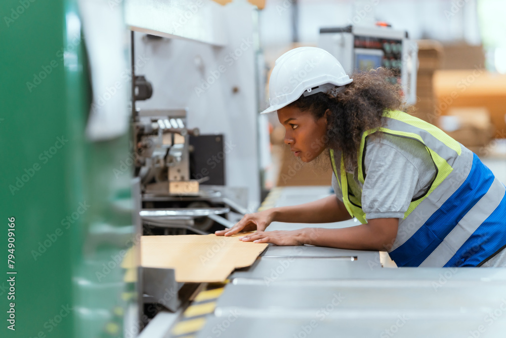 Machine operators work in a large paper factory and check stock of cardboard boxes. Machine operators work in a large paper factory and check stock of cardboard boxes.