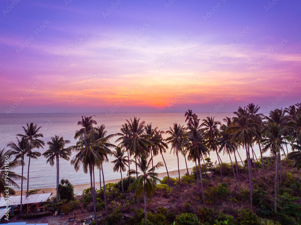 Obraz premium Beautiful sunset on a tropical paradise beach. Tropical sunset with palm tree silhouette. 