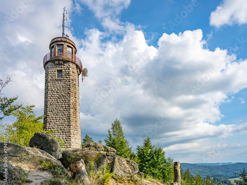 The stone lookout tower of Prosecsky Hreben stands on rocky terrain against a partly cloudy sky, offering a potential view of the surrounding landscape. photo
