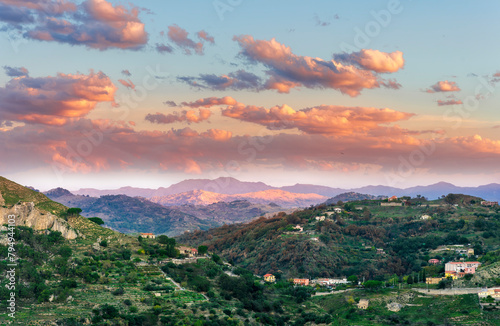 evening sunset mountain view of hightland landscape with green hills and mountains and amazing blue sea water with beautiful cloudy sky on background photo