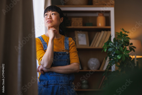 Woman looking out the window and relaxing at home