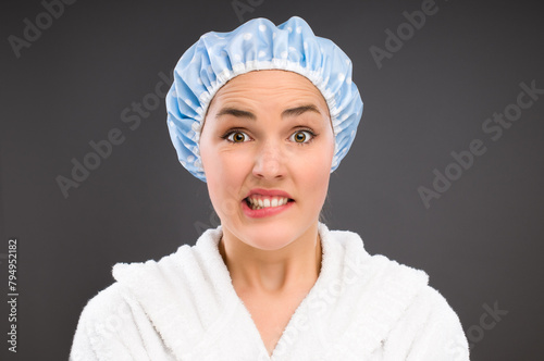 Confused, portrait and woman with shower cap for bathing, cleaning and hygiene isolated on dark background. Question, funny and face of student in water proof hat for wellness by studio backdrop