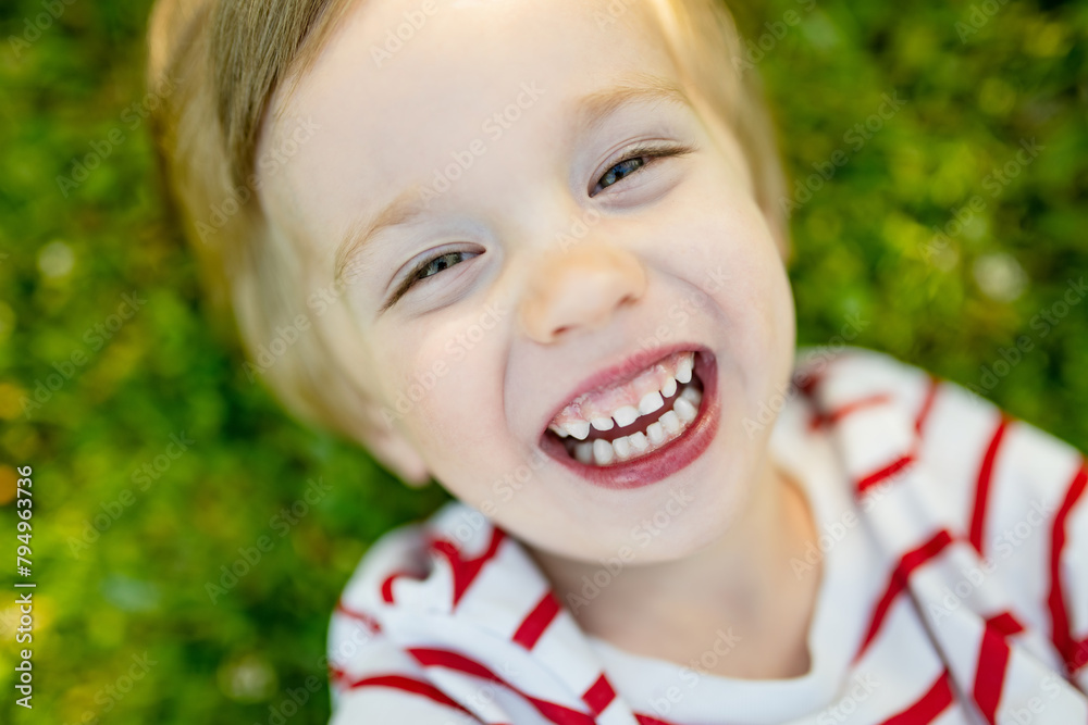 Adorable little boy having fun outdoors on sunny summer day. Kid running outdoors. Child exploring nature. Summer activities for small kids. Adorable little boy having fun outdoors on sunny summer day. Kid running outdoors. Child exploring nature. Summer activities for small kids.