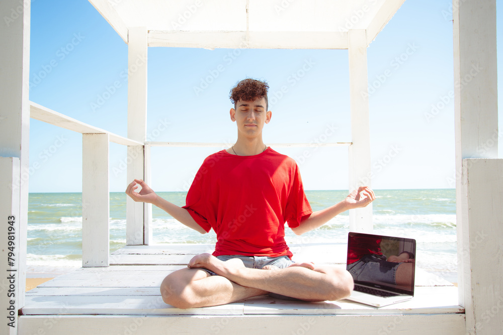 A young attractive man meditates by the sea. A young attractive man meditates by the sea.