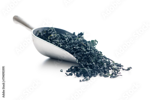 Dried wakame seaweed in scoop isolated on white background.
