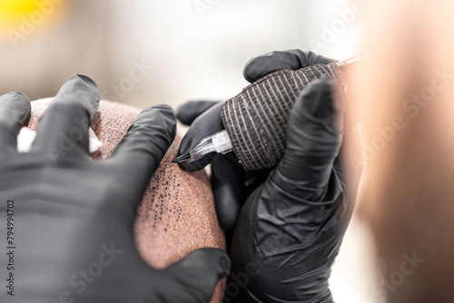 Obraz na płótnie Detalle de maquina de tatuar realizando micropigmentación capilar w salonie