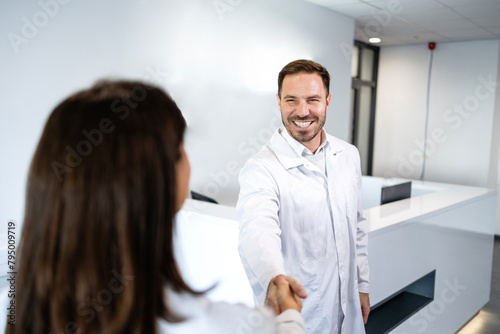 Team of scientists shaking hands at work.