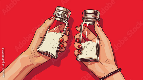 Female hands holding pepper and salt shakers on red background photo