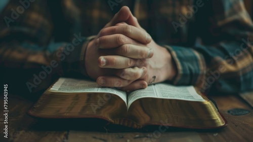 Hand praying with bible