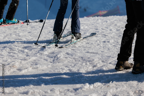 concetto di: sciare in montagna, primo piano sulle gambe di varie persone irriconoscibili che si preparano per sciare su una pista da sci, in inverno, in montagna © PhotoMet