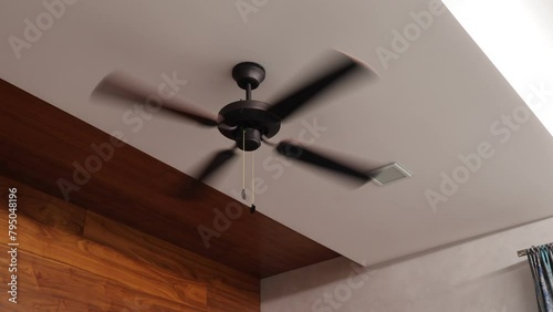 Wooden ceiling fan. Modern room cooling device with speed control. Summer and heat in the room. photo