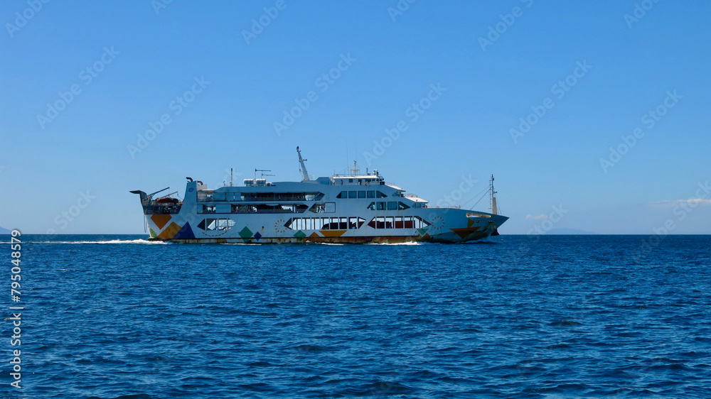Cargo-passenger ferry at sea. A cargo-passenger ferry moves along the waves of the blue sea. Cargo-passenger ferry at sea. A cargo-passenger ferry moves along the waves of the blue sea.