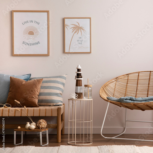 Interior design of cozy and summer living room with rattan armchair, couch, pillows, mock u poster frame, side table, bamboo ladder, decoration, carpet and personal accessories. Stylish home decor.
