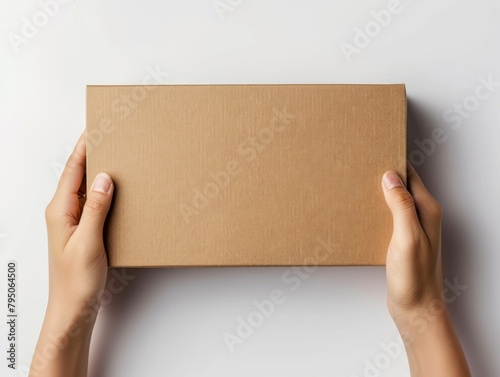 Hands holding a plain cardboard box on a gray background © kilimanjaro 