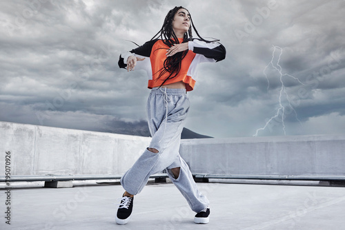 Woman  dance and hip hop outdoor on city rooftop with lightning storm and cool gen z streetwear fashion. Girl  moving and dancer with creative energy on apartment balcony and urban style or freedom