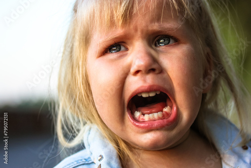 Unhappy child crying loudly with mouth open because of parents' divorce. Negative emotions. Bullying, child abuse protection. Misery. Child of war.