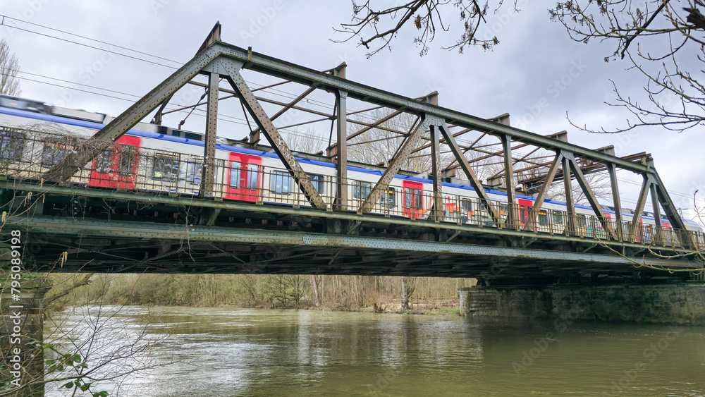 A train is crossing a bridge over the water under a cloudy sky Hanover Germany A train is crossing a bridge over the water under a cloudy sky Hanover Germany