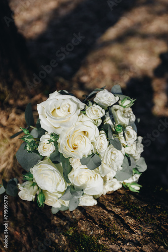 bride's wedding bouquet of white roses on a wooden dark background