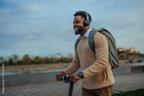 Man with scooter and headphones enjoying ride (ID: 795103534)