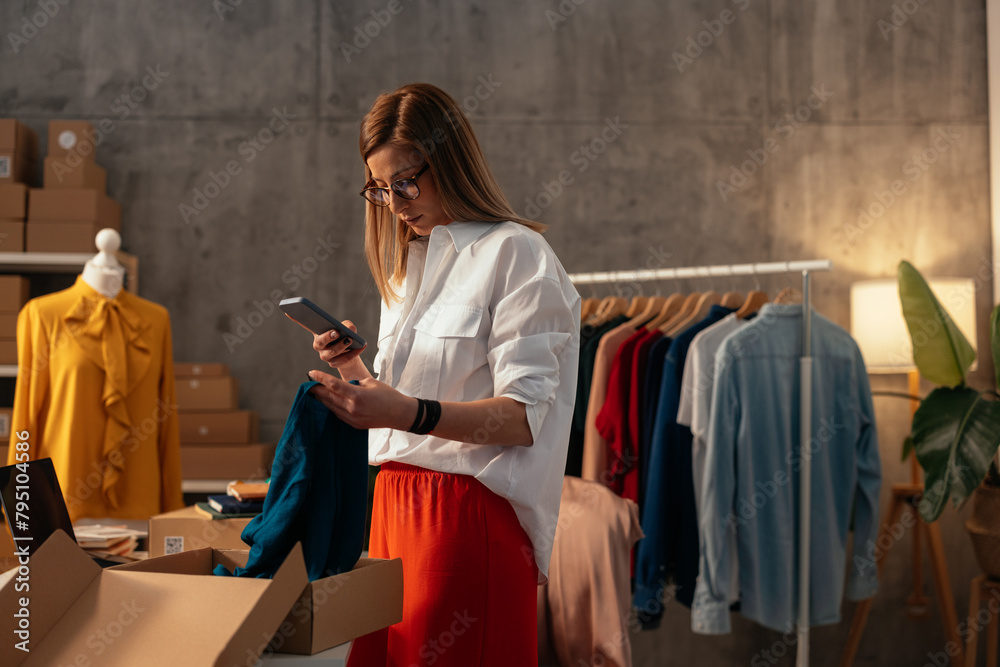 Woman checking her phone amidst packing orders