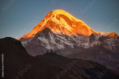 Glowing Mount Kazbek in Georgia with church in foreground  photo
