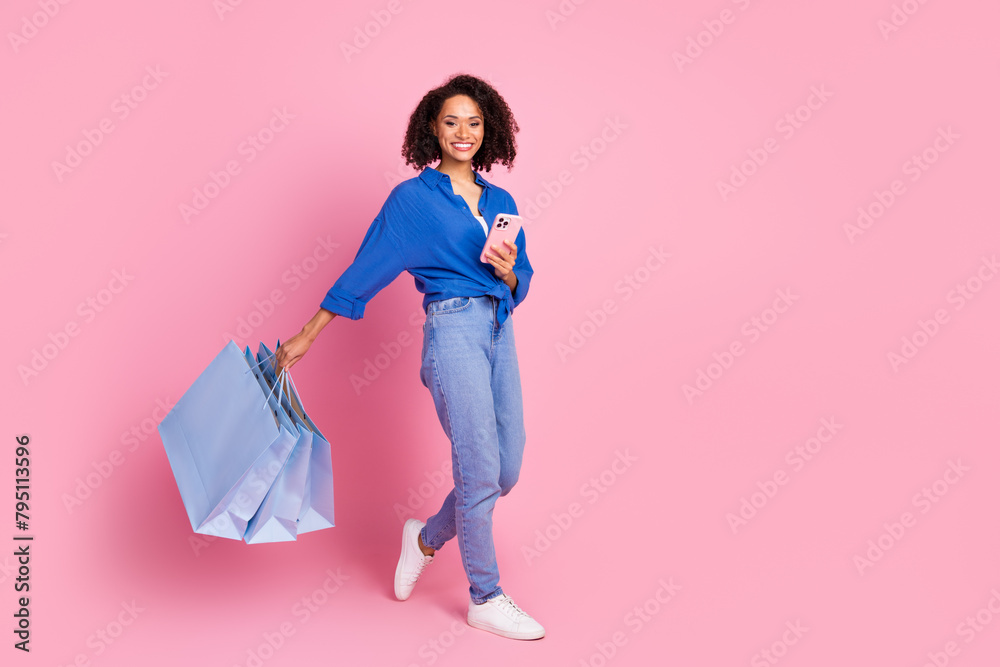 Photo of lovely charming cheerful girl dressed stylish blue clothes walk empty space isolated on pink color background