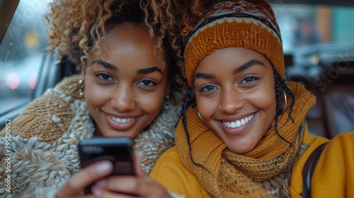 Two Women Smiling While Looking at a Cell Phone
