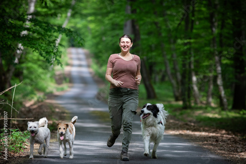 happy woman with her dogs in the forest