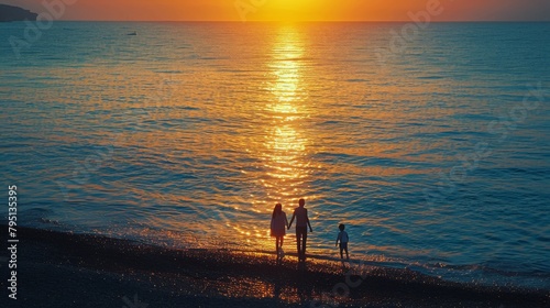 Group of People Walking Along Beach at Sunset