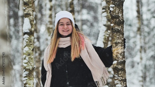 Portrait of a girl in winter in a birch forest.