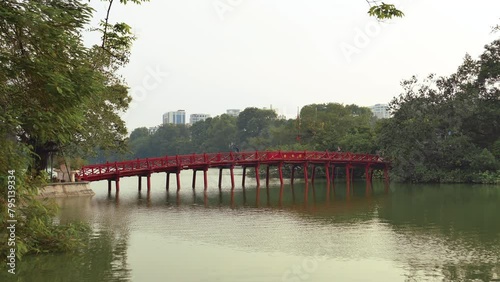 Hanoi, Vietnam - August 23, 2023: The Huc Bridge (Welcoming Morning Sunlight Bridge) in Hoan Kiem Lake photo