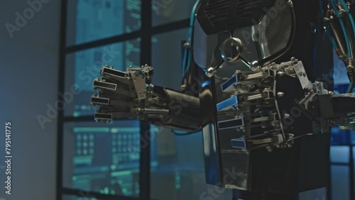 Midsection shot of clenched metal hands of AI humanoid robot in dark electronics laboratory photo