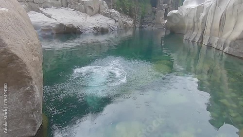 man jumping in mountain river blue clear water at day photo