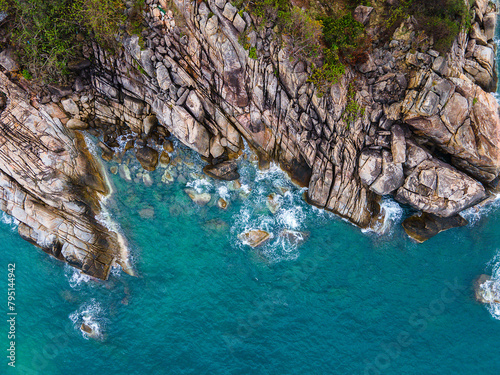 Aerial top down view of a beach with turquoise clear water rocks and trees in Koh Phangan Thailand