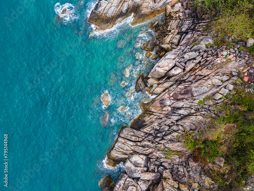 Aerial top down view of a beach with turquoise clear water rocks and trees in Koh Phangan Thailand